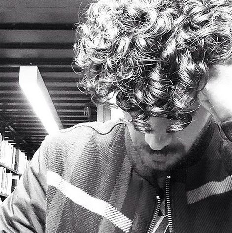 a-black-and-white-photograph-of-a-curly-haired-male-with-a-cool-long-hairstyle-for-his-coils-and-kinks
